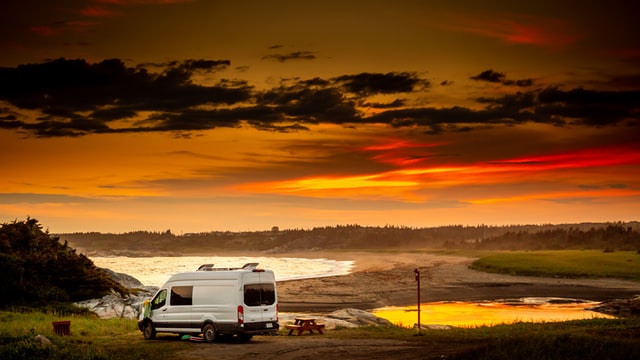 A van parked under a sun set